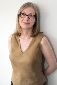 judith hamera smiling with glasses in gold top