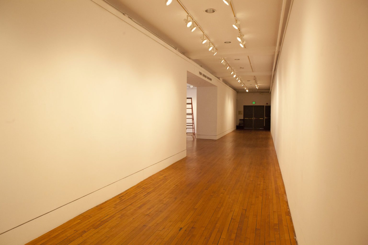 white gallery walls long hallway and spotlights