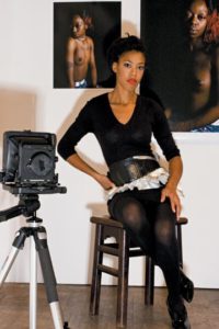 deana seated on stool in studio by camera tripod