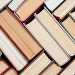 Aerial view of hardcover books stacked in crosshatch pattern.