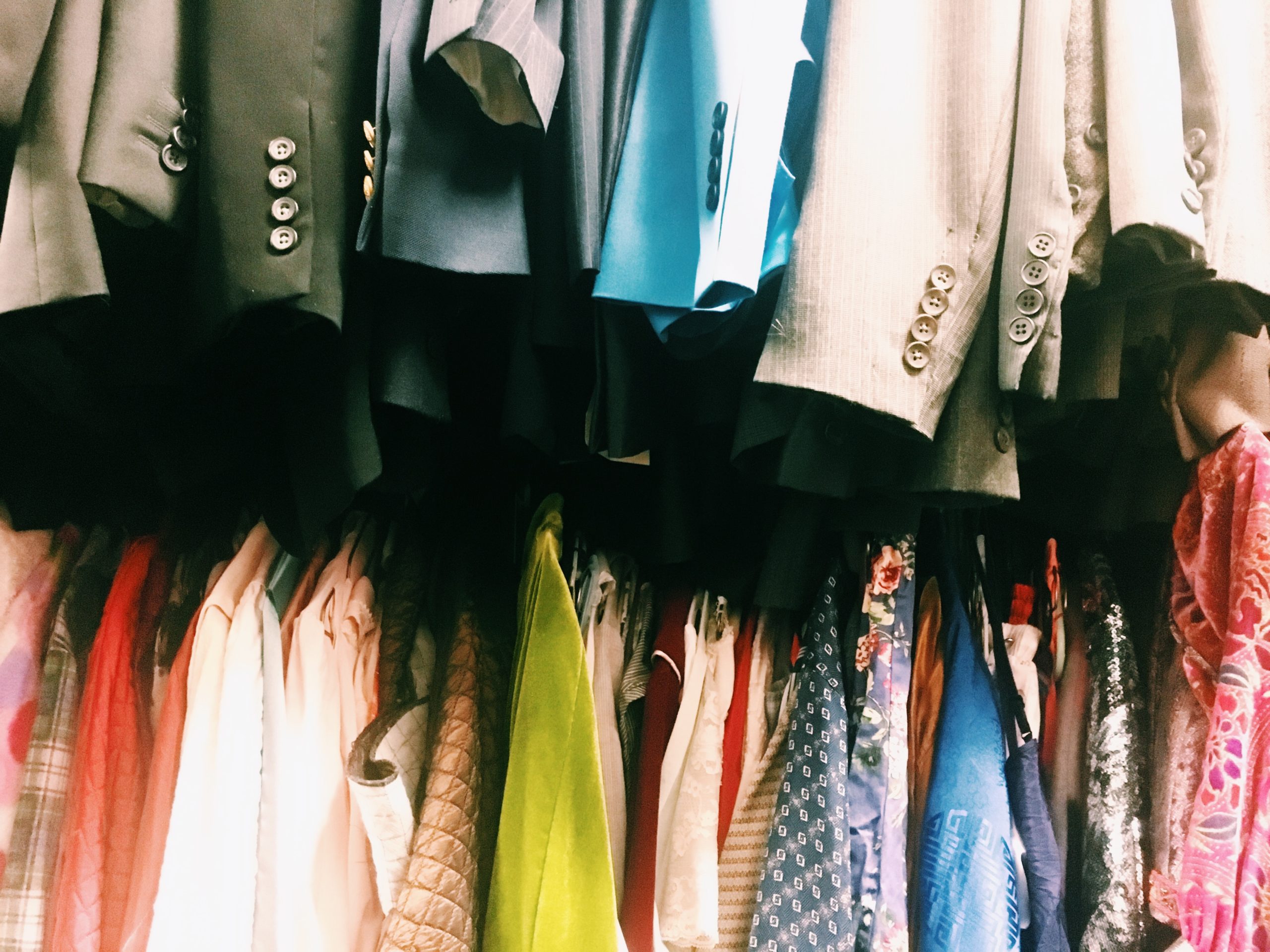 colorful clothing hangs tightly packed on racks