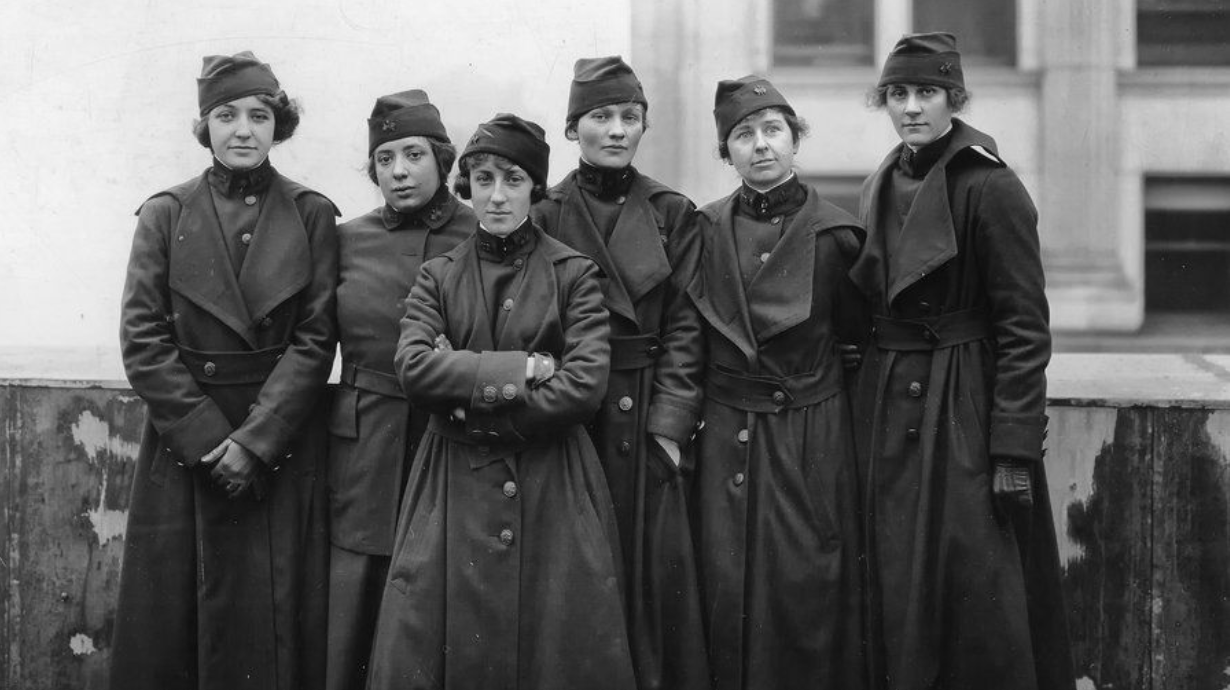 six women in military dress stand before camera