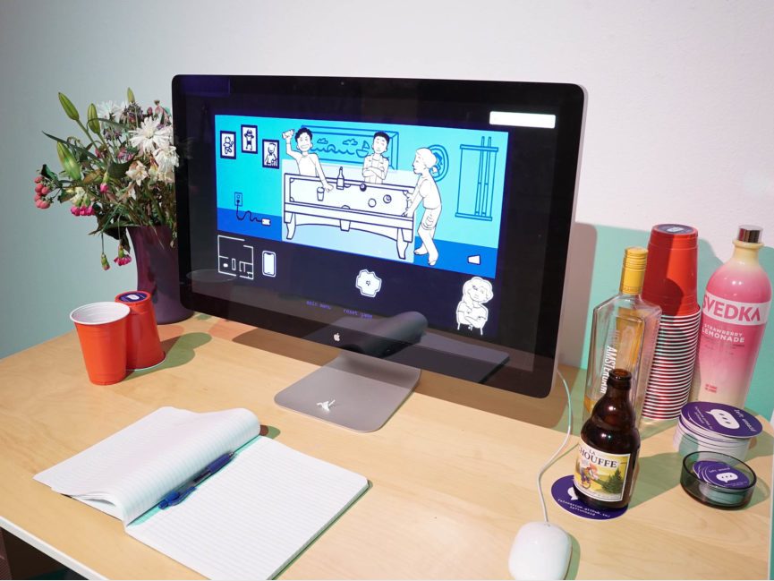 A computer sits on a desk with a cartoon style illustration on the screen.