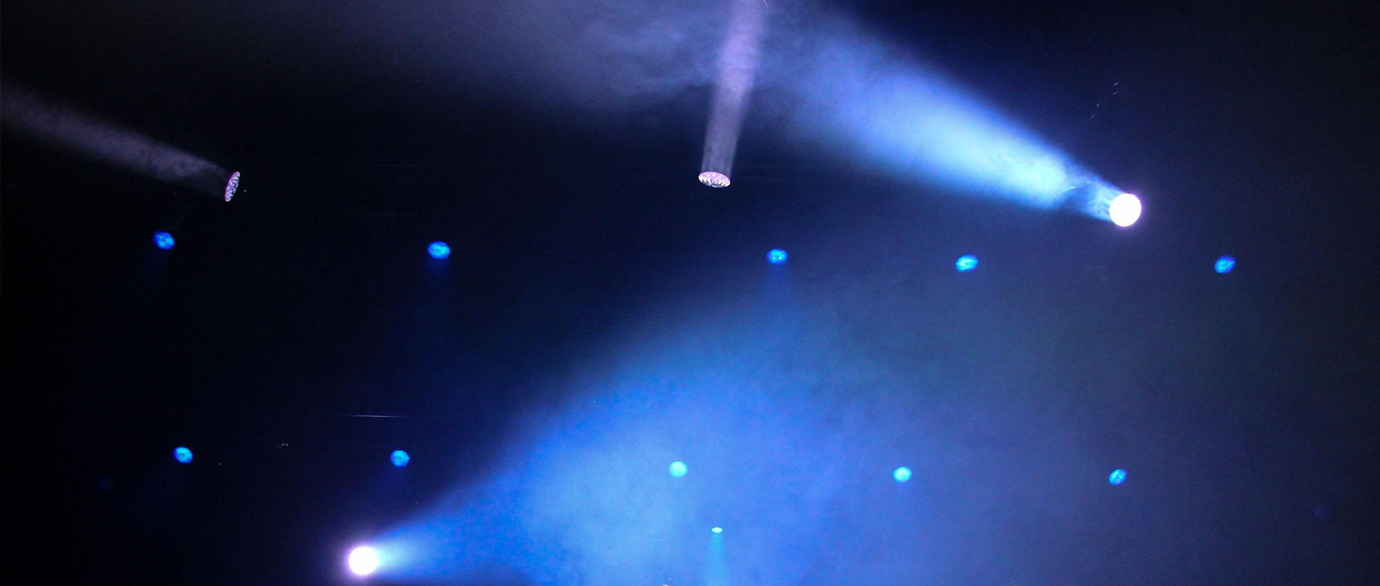 theater spotlights scattered on dark blue wall