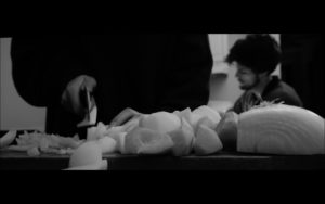 closeup view of hand chopping onions with knife on countertop