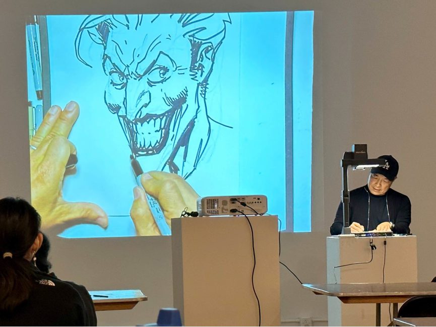 An artist draws a comic book figure using an overhead projector