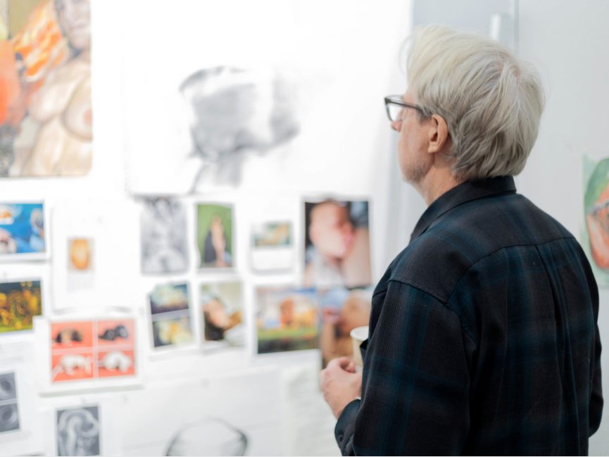 A person looks at artwork on a wall in a gallery