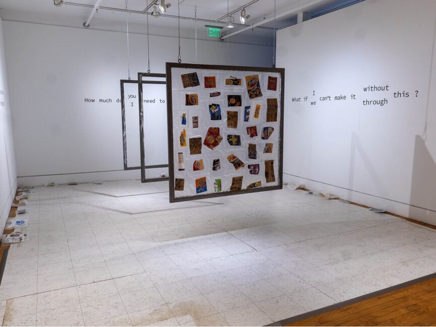 Frames holding various artifacts consisting of snack bags hang from the ceiling