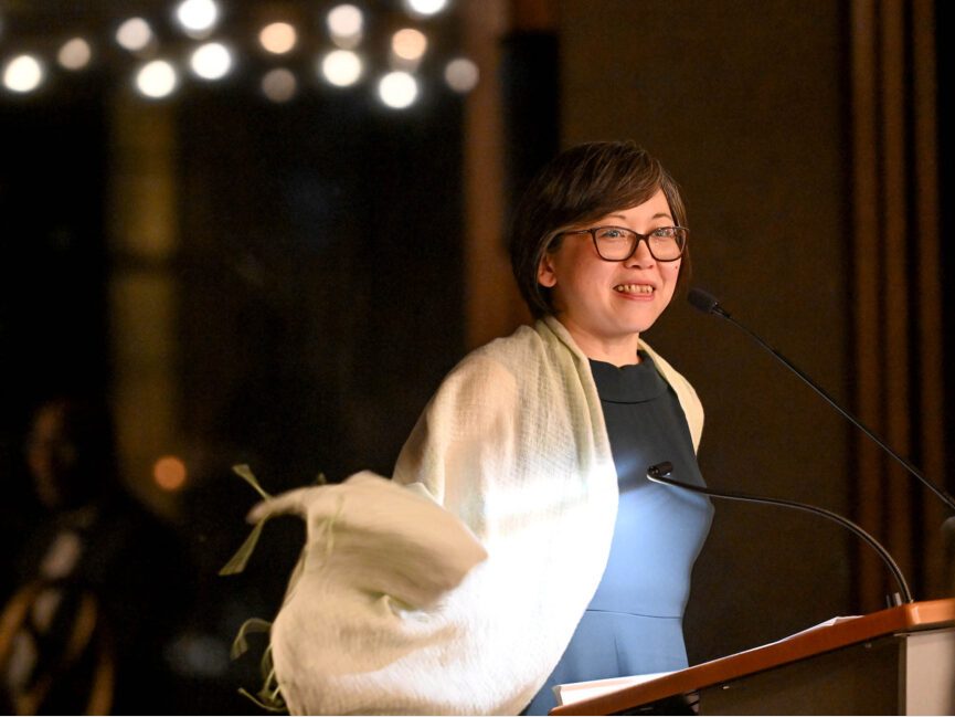 A person talks at a podium at a formal gathering