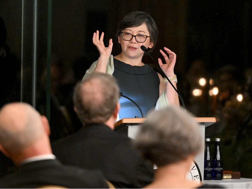 A person talks at a podium at a formal gathering