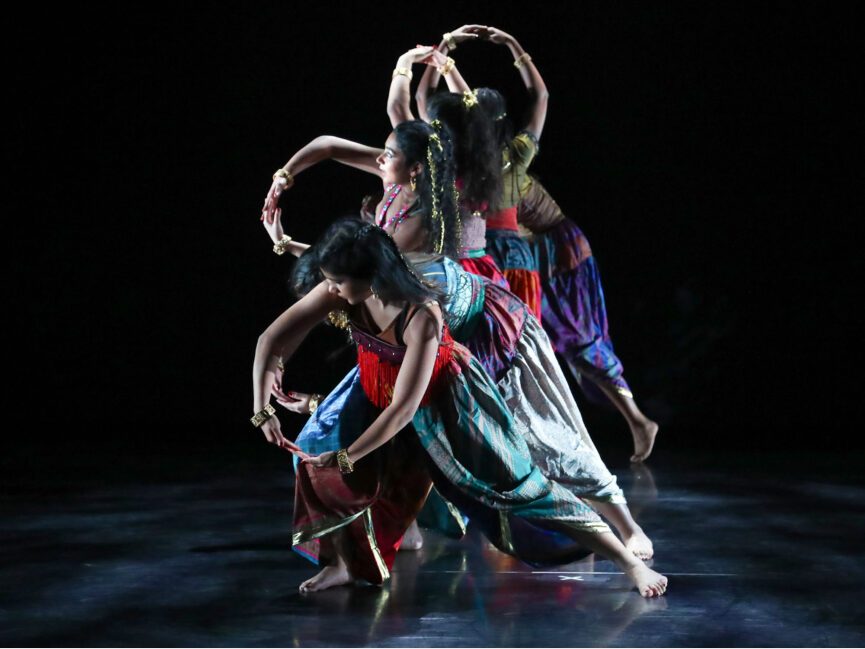 A row of dancers perform on stage