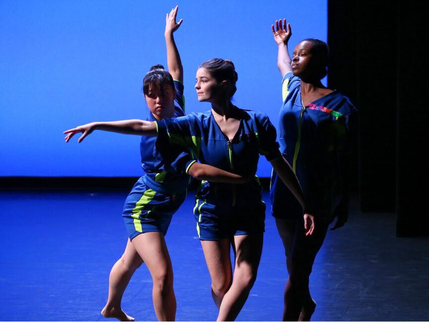 Three dancers perform together on stage