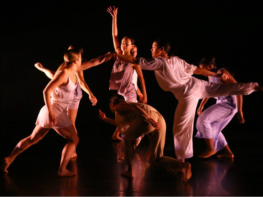A group of performers dance on stage.