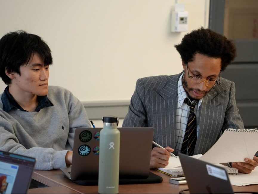 E.S. Glenn works beside a student in a classroom