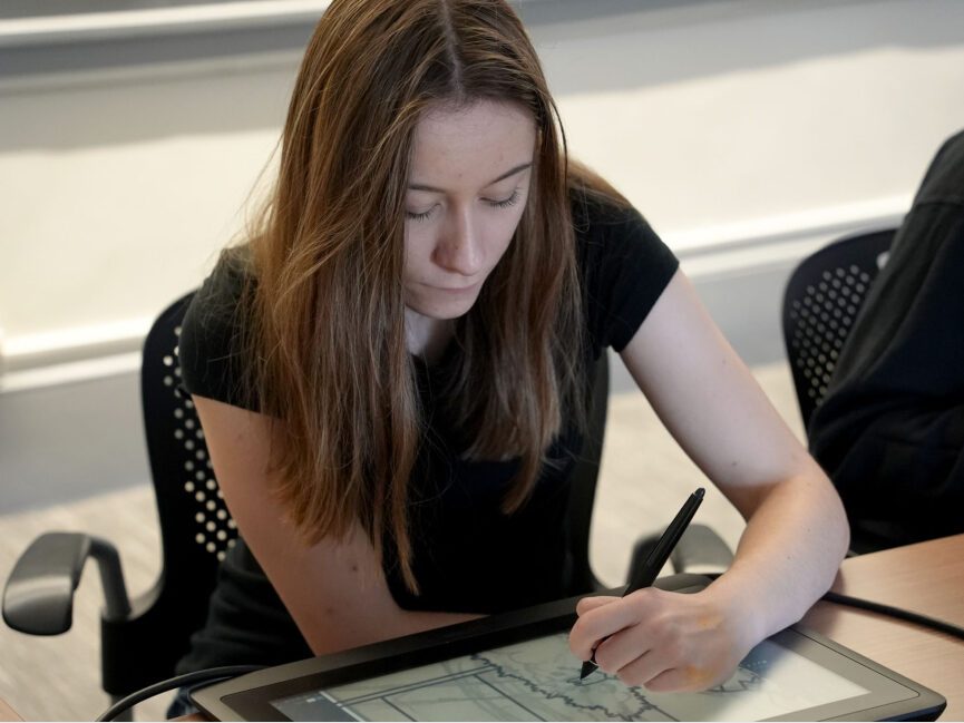 A student works on an illustration on their digital tablet