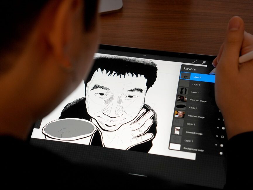 A student works on an illustration on their digital tablet