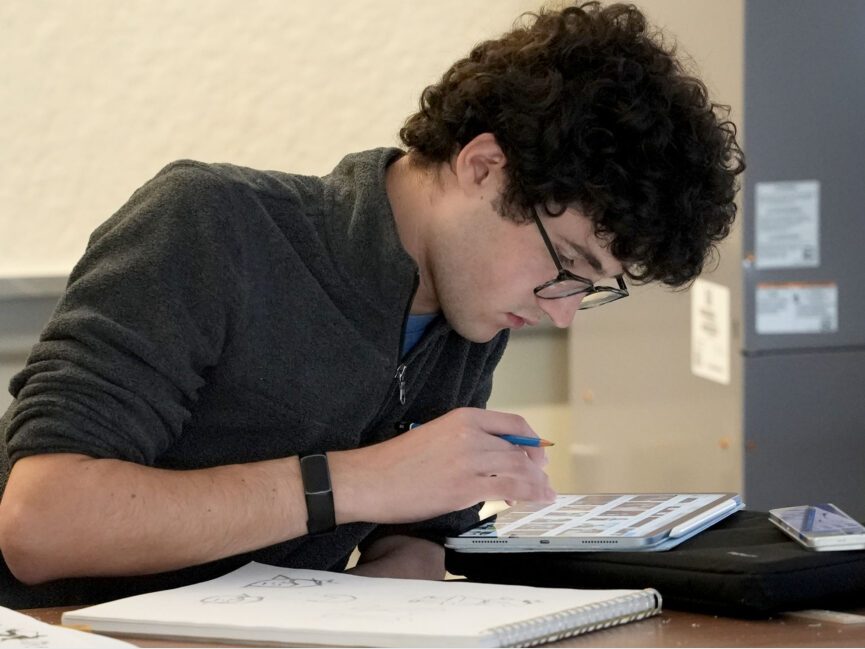 A students looks closely at a digital tablet