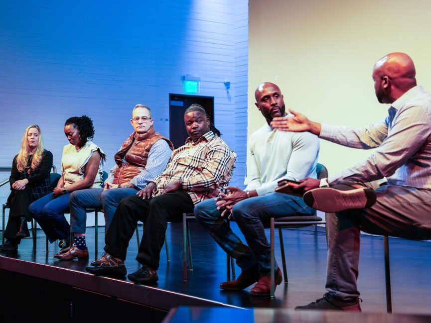 A panel sits on a stage an has a discussion