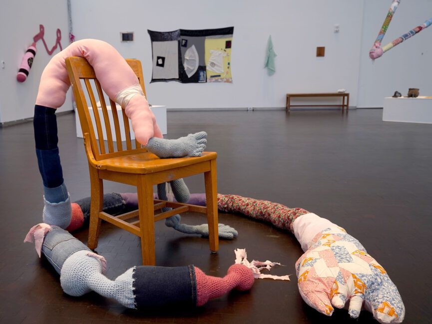 A chair is draped with a stuffed fabric sculpture
