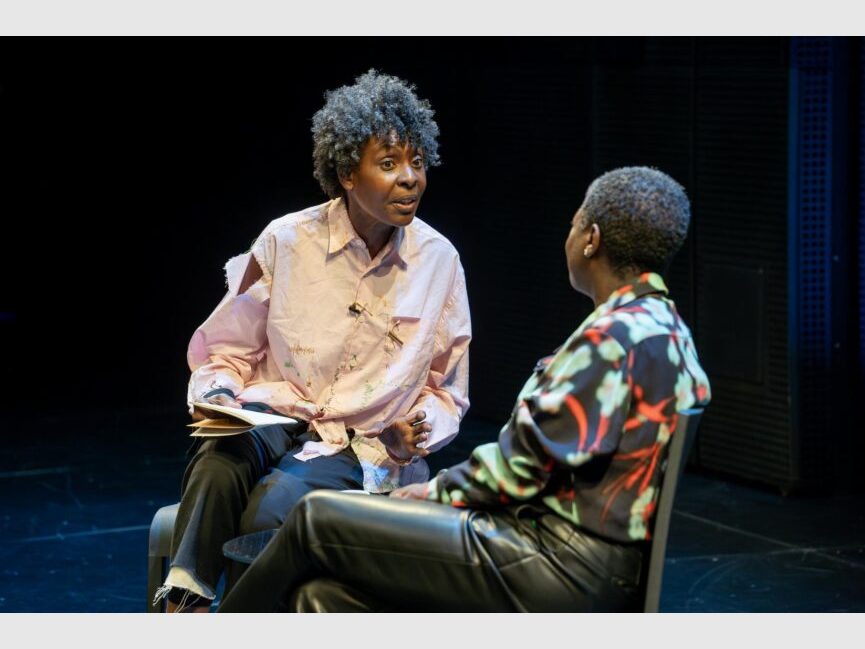 Helga Davis and Thelma Golden (seen from behind) sit and talk.