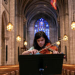 A student plays a viola in the main aisle of Princeton University Chapel