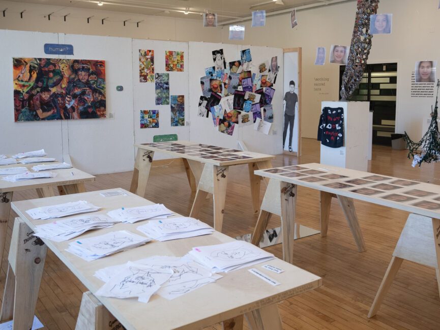 Artwork covers the walls and tables in a gallery