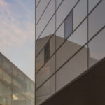 Reflections of the sky seen in glossy exterior windows of the Lewis Arts complex.