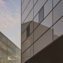 Reflections of the sky seen in glossy exterior windows of the Lewis Arts complex.