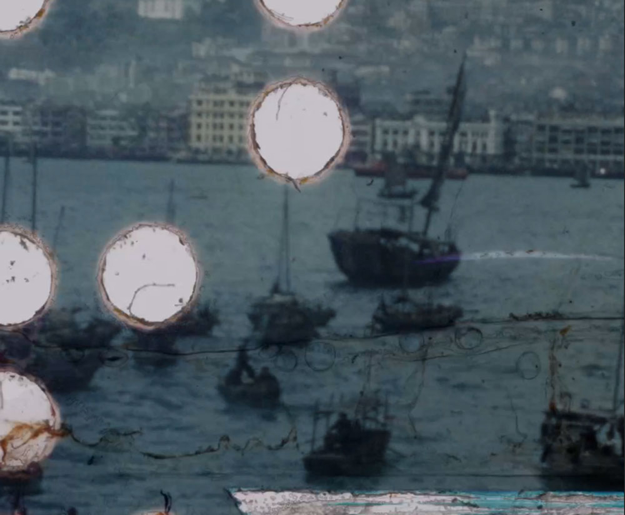 A scene of boats sailing on water with a cityscape in the background, interrupted by large white circles.