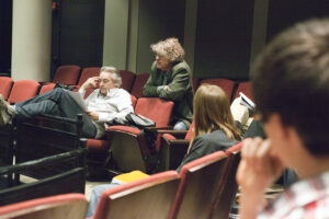People sit scattered in chairs in an auditorium